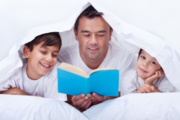 Father and sons reading book